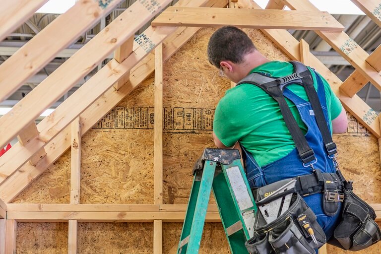 man on a ladder working on construction site